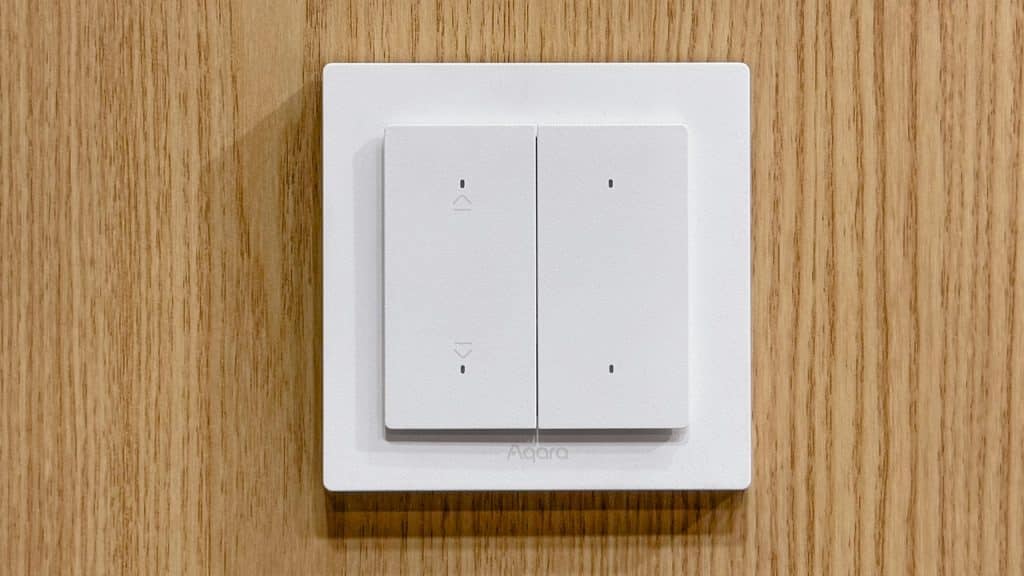 Aqara Shutter Switch H2 EU mounted on a wooden wall.